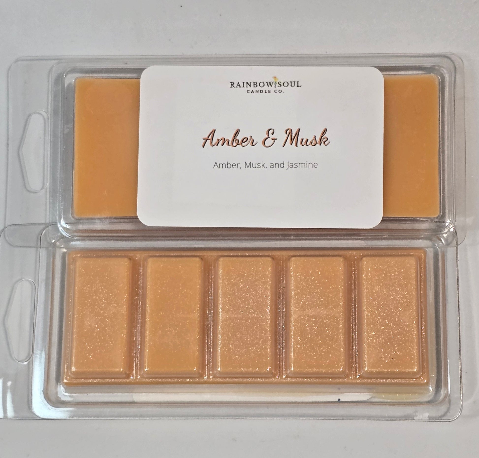 Amber-colored wax melt snap bars with a label on a white background