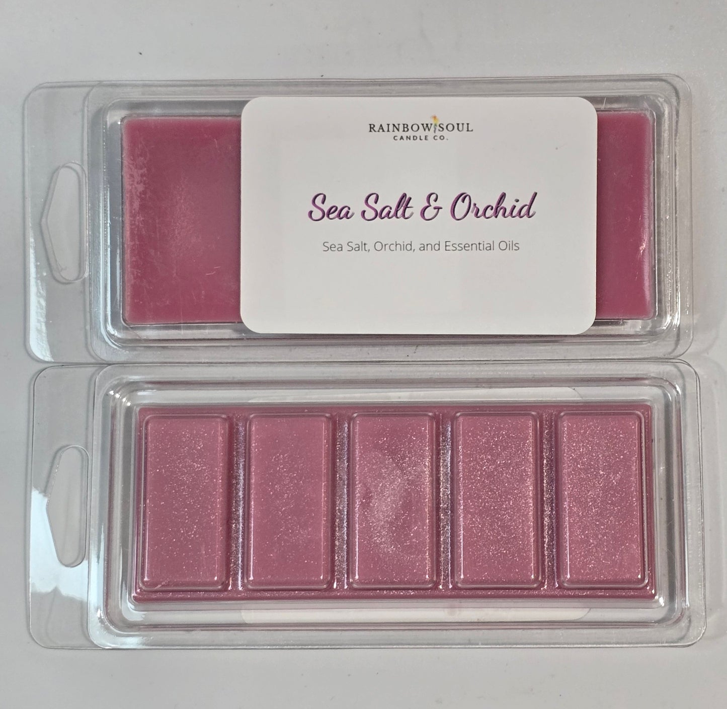 Pink wax melt snap bars in a clear container with a label on a light gray background