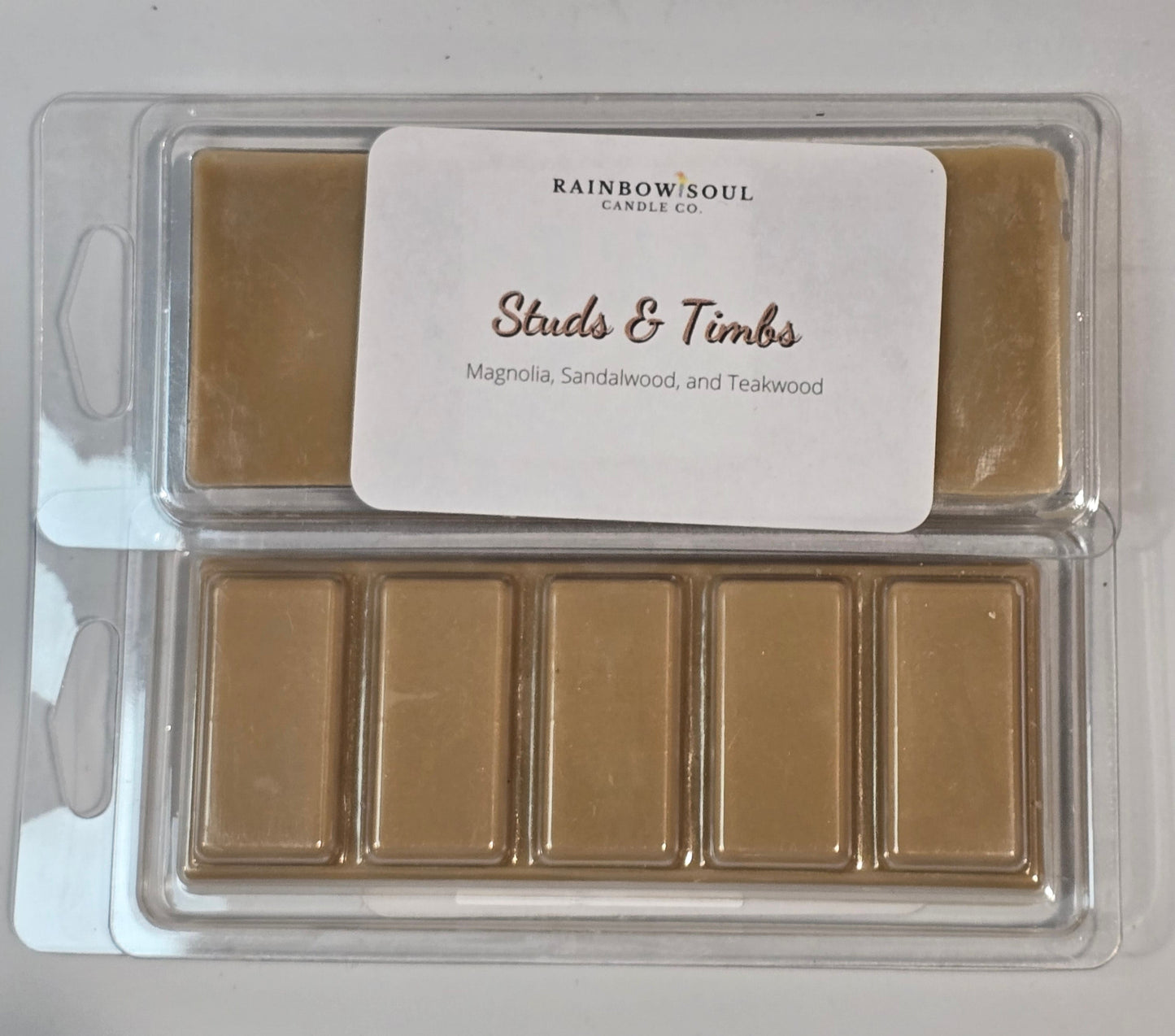 Gold-colored wax melt snap bars with a label on a gray background